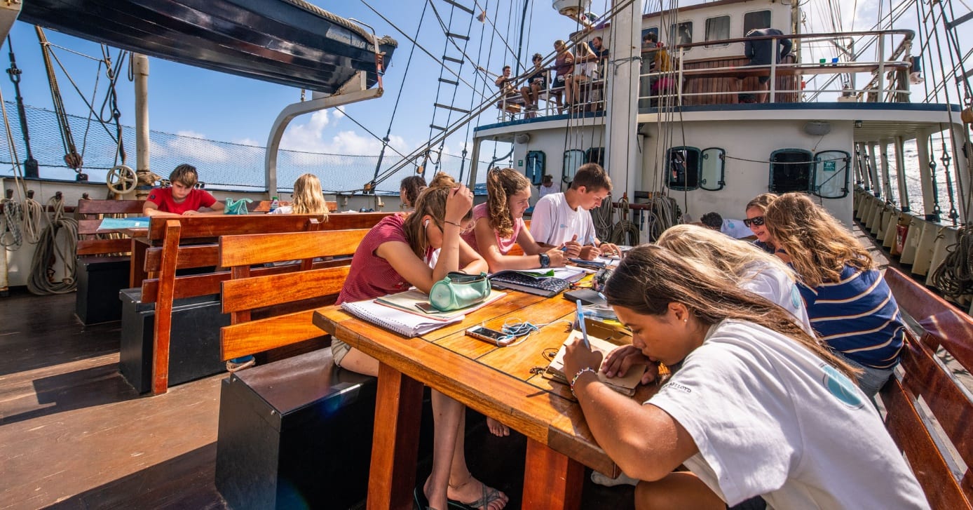 Schoolwerk aan dek van de Thalassa